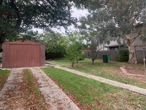 a driveway in a yard with a red garage at Lilys Place in Cowes