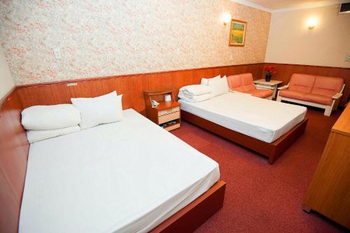 a hotel room with two beds and a chair at New May Flower Hotel in Taipei