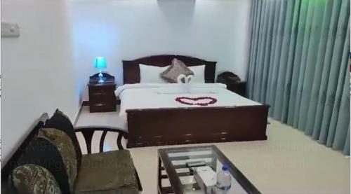 a bedroom with a large bed and a table with a table at Blue Moon Resort & Eco Park, Bogura, Bangladesh in Bogra