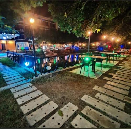 a group of picnic tables and lights at night at Blue Moon Resort & Eco Park, Bogura, Bangladesh in Bogra