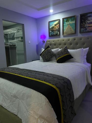 a bedroom with a large bed with purple walls at Bayfront Luxury beachfront escape with Pool in Portmore Book Now in Portmore
