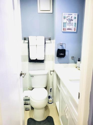 a bathroom with a white toilet and a sink at Bayfront Luxury beachfront escape with Pool in Portmore Book Now in Portmore