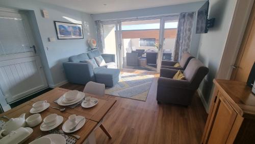 an aerial view of a living room with a table and chairs at TWIN COVES at Curlew 1, The Cove, Brixham in Brixham