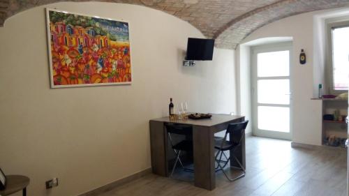 a dining room with a table and a painting on the wall at A Casa di Nene in Rivanazzano