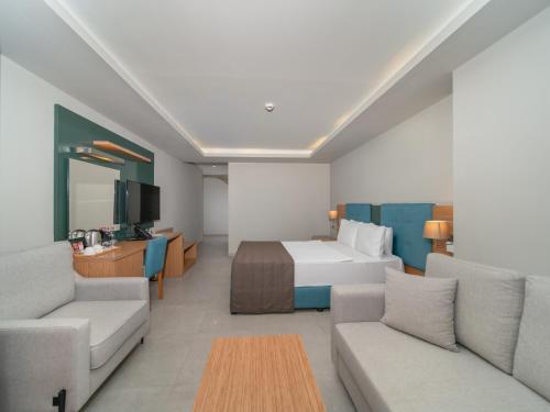 a hotel room with a bed and a couch at Ambrosia Hotel Beach & Spa in Bitez