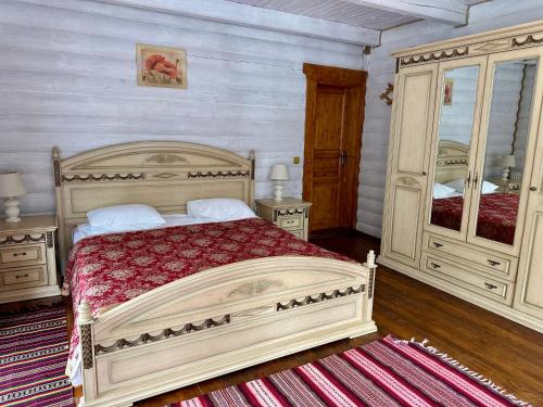 a bedroom with a large bed and two dressers at Hotel Dykyi Med in Tatariv