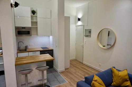 un salon avec un canapé bleu et une cuisine dans l'établissement Studio calme et tout équipé centre historique, à Aix-en-Provence