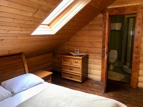 a bedroom in a log cabin with a bed and a window at Hotel Dykyi Med in Tatariv