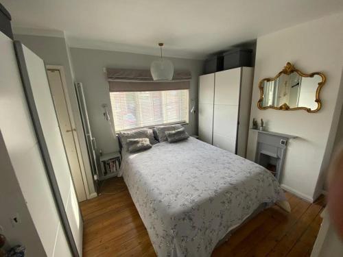 a bedroom with a bed and a mirror at Ely Cathedral family home in Ely