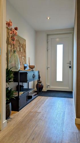 a room with a door and a table with a plant at Bed&Bubbels 256 in De Koog