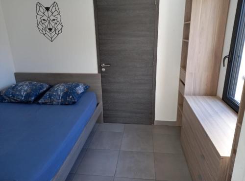 - une petite chambre avec un lit bleu dans l'établissement porticcio, à Porticcio