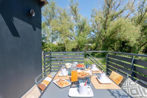 une table avec de la nourriture et des boissons sur un balcon dans l'établissement Appartement La Baule Pornichet Terrasse - Cuisine - Calme - Wifi - Parking Gratuit, à Pornichet