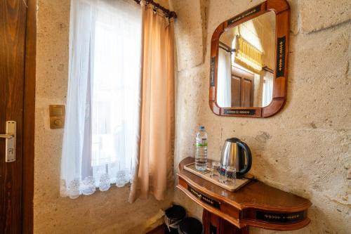 a bathroom with a sink and a mirror and a window at Asyada Suites Hotel in Nevsehir