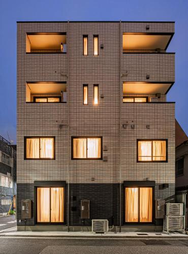a tall brick building with many windows at 67 Apartment Ueno in Tokyo