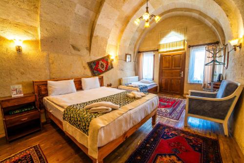 a bedroom with a large bed in a stone room at Asyada Suites Hotel in Nevsehir