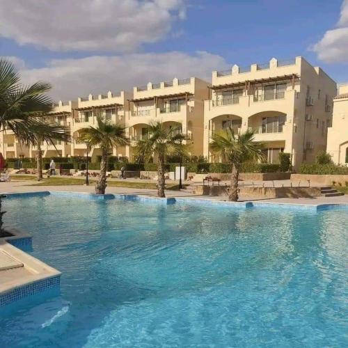 a large swimming pool in front of a building at العين السخنة palm beach resort شاليه عائلات فقط in Ain Sokhna