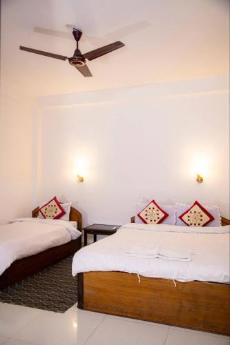 a bedroom with two beds and a ceiling fan at Hotel Misty Nepal in Sauraha