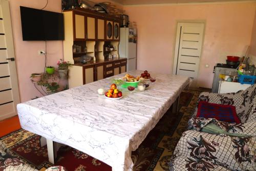 a kitchen with a table with a bowl of fruit on it at "White swan" Home in Kara-Talaa