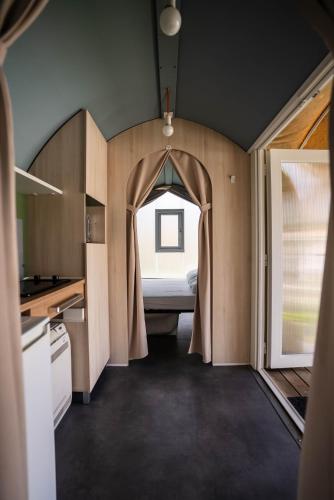 a small kitchen with a bed in the middle of a room at Camping Fossalta in Lazise