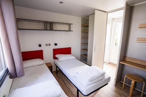 two beds in a room with a window at Camping Fossalta in Lazise