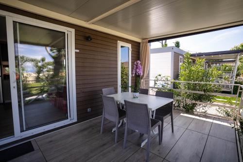 a porch with a table and chairs on a patio at Camping Fossalta in Lazise