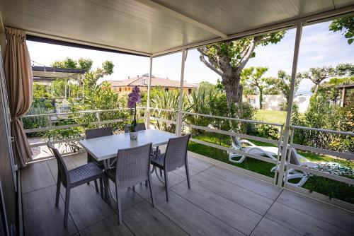 a patio with a table and chairs on a deck at Camping Fossalta in Lazise