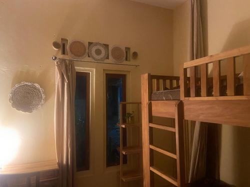a bedroom with a bunk bed next to a door at Social Ducks Hostel Borobudur in Borobudur