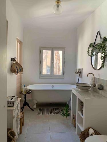 une salle de bain blanche avec une baignoire et un lavabo dans l'établissement Grand appartement centre historique, à Arles