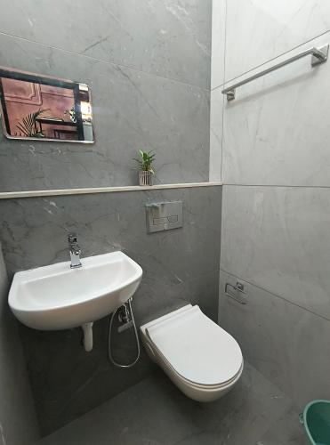 a bathroom with a white sink and a toilet at The Serene Retreat in Eramalloor