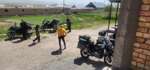 a group of people standing around motorcycles on a dirt road at CBT1 Sary-mogul in Sary-Mogul