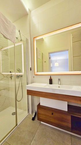 a bathroom with a shower and a sink and a mirror at Bel Mare - Muszelka in Międzyzdroje