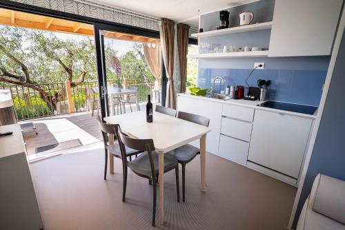 a kitchen with a table and chairs and a balcony at Camping Fossalta in Lazise