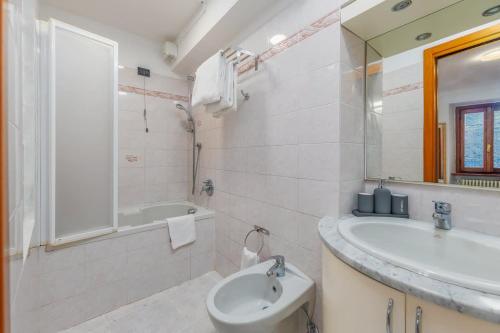 a bathroom with a sink and a toilet and a tub at The Twilight - A Window view of the Lake in Blevio