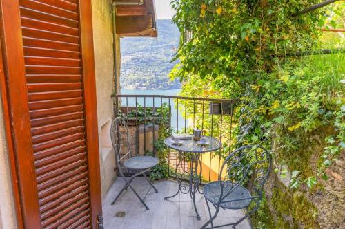 a small table and chairs on a balcony with a view at The Twilight - A Window view of the Lake in Blevio