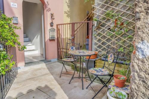 a patio with chairs and a table and a wall at The Twilight - A Window view of the Lake in Blevio