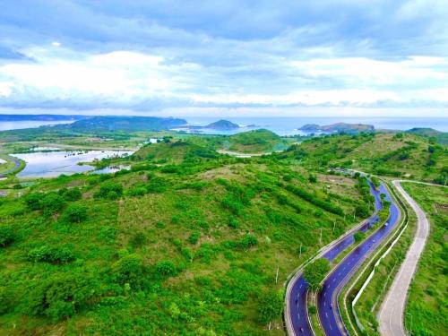 a road on a hill with the ocean in the background at Truntum Boutique Mandalika in Kuta Lombok