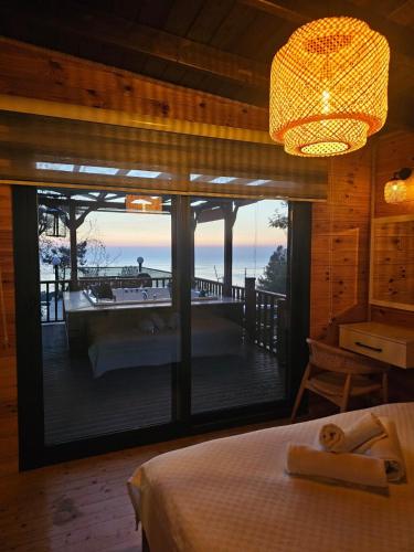 a bedroom with a bed and a view of a deck at Sapolto Villas Faralya in Fethiye