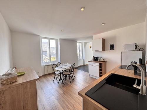 une cuisine avec un évier et une table avec des chaises dans l'établissement L'Atelier - Centre - Vieux Mans - 4 pers, au Mans