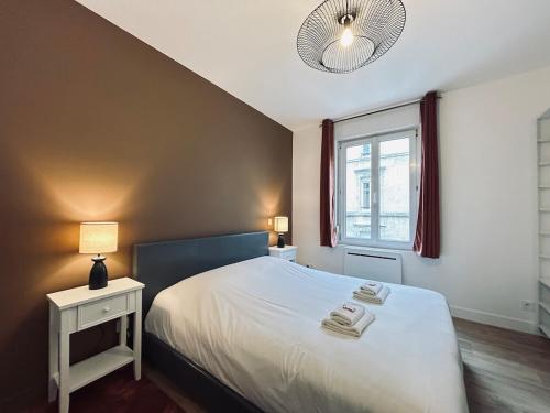 une chambre avec un lit avec deux serviettes dessus dans l'établissement 3 Clairmarais charmant T2 proche centre-ville, à Reims