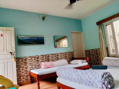 un salon avec deux lits et un canapé dans l'établissement Hotel Unicorn, à Pokhara