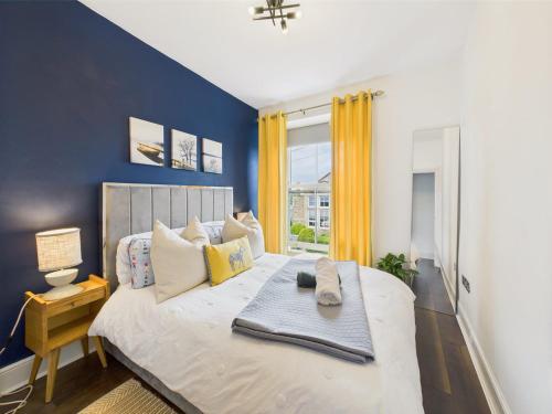a bedroom with a large bed with a blue wall at Central Falmouth Flat with Free Parking in Falmouth