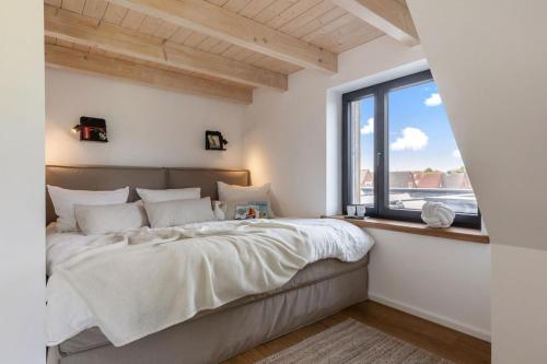 une chambre avec un grand lit et une fenêtre dans l'établissement Luxus-Ferienhaus DS11, à Fehmarn