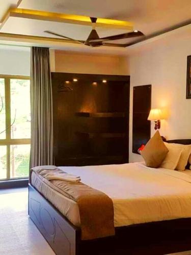 a bedroom with a bed with a ceiling fan at Majestic Mano in Shillong