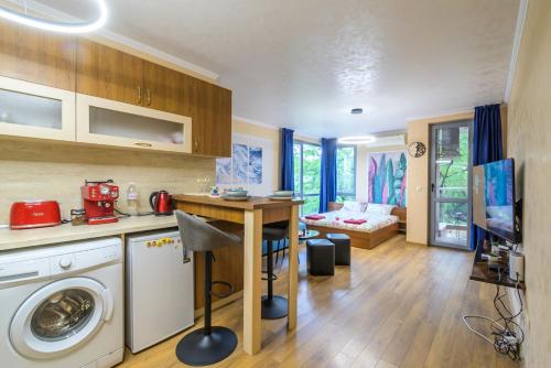 a kitchen and living room with a washing machine in it at Comfy & Chic Apartment , SWU , FREE Parking in Blagoevgrad