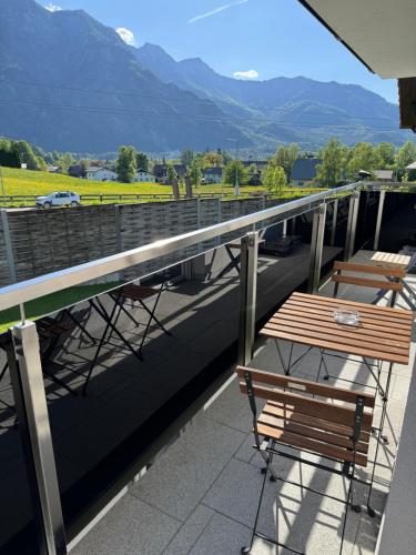 a balcony with a table and chairs and mountains at Austrian Apartments in Bad Goisern