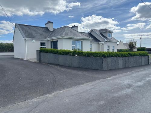a white house with a fence in front of it at Mullally House Liscannor (Wild Atlantic Way) in Liscannor