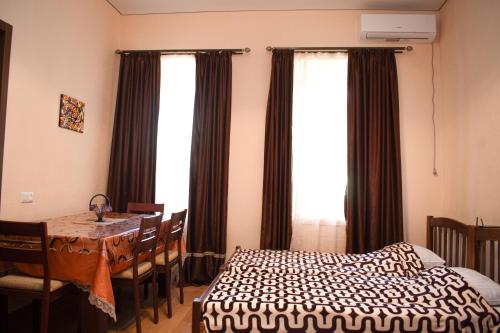 Un dormitorio con una cama y una mesa y una ventana. en Apartment In City Center, en Tiflis