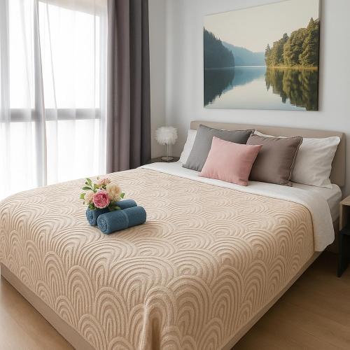 a bedroom with a large bed with flowers on it at Ideo O2 BTS Bangna in Bangkok