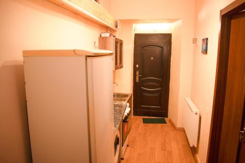 cocina con nevera y puerta negra en Apartment In City Center, en Tiflis