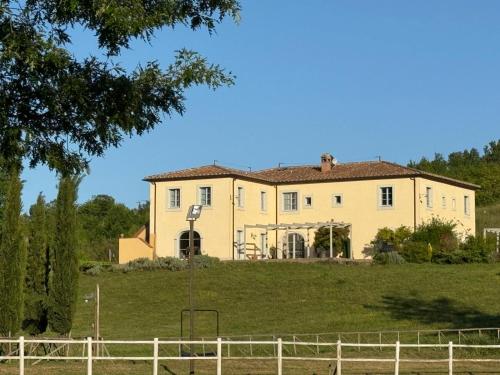 duży dom na szczycie trawiastego wzgórza w obiekcie Agriturismo In Campagna w mieście Santa Fiora